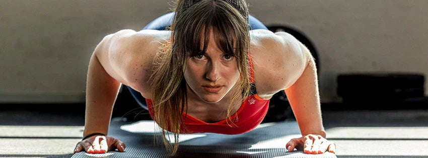 Femme en brassière de sport qui fait des pompes