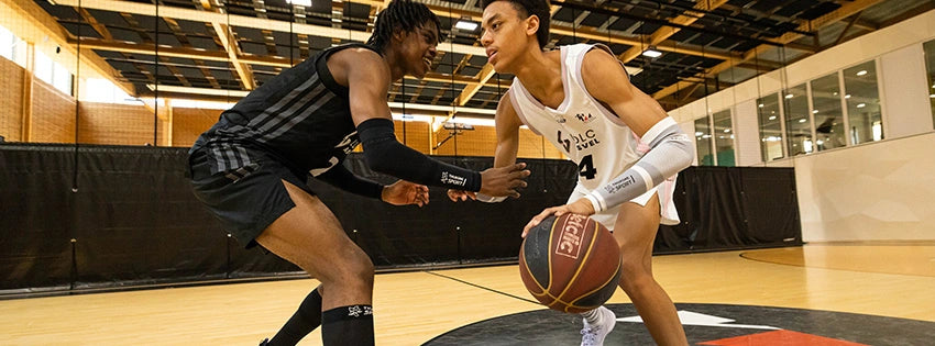 Joueur contre joueur au basket portant de la compression sportive