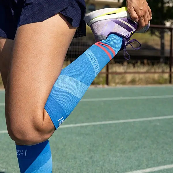 étirement sur piste avec chaussettes de compression sportive bleu clair